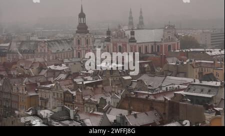 Vue de Poznan Pologne sur un jour de novembre enneigé avec les toits de vieilles maisons et clochers d'églises catholiques Banque D'Images