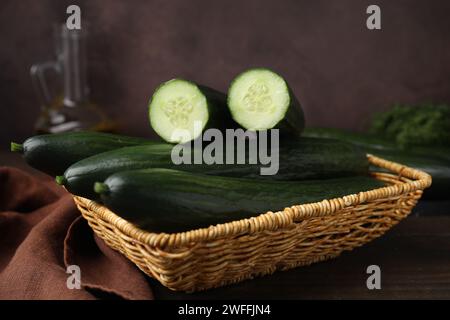 Concombres frais dans le panier en osier sur la table, gros plan Banque D'Images