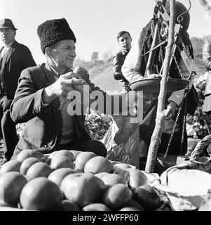 Comté de Vrancea, Roumanie, env. 1979. Paysan vendant des légumes à une foire de campagne, en utilisant une balance à main vintage. Banque D'Images