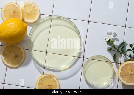 Deux boîtes de Pétri en verre remplies d'huile essentielle extraite de citron sur fond de carreaux de mosaïque. L'acide citrique trouvé dans le citron (Citrus limon) brick Banque D'Images