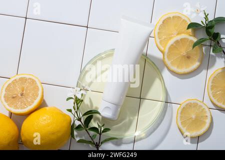 Boîte de Pétri en verre contenant un liquide jaune clair et un tube blanc avec des branches de fleurs et des tranches de citron. Citron (Citrus limon) aide à combattre Wri Banque D'Images