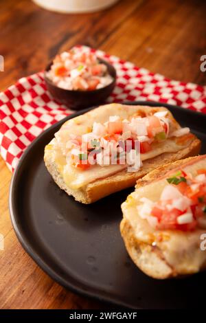 Molletes. Recette mexicaine à base de pain bolillo fendu dans le sens de la longueur, tartiné de haricots frits et de fromage gratiné, ajoutant de la sauce Pico de gallo et un peu de pro Banque D'Images