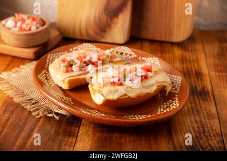 Molletes. Recette mexicaine à base de pain bolillo fendu dans le sens de la longueur, tartiné de haricots frits et de fromage gratiné, ajoutant de la sauce Pico de gallo et un peu de pro Banque D'Images