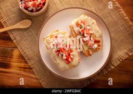 Molletes. Recette mexicaine à base de pain bolillo fendu dans le sens de la longueur, tartiné de haricots frits et de fromage gratiné, ajoutant de la sauce Pico de gallo et un peu de pro Banque D'Images