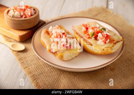 Molletes. Recette mexicaine à base de pain bolillo fendu dans le sens de la longueur, tartiné de haricots frits et de fromage gratiné, ajoutant de la sauce Pico de gallo et un peu de pro Banque D'Images