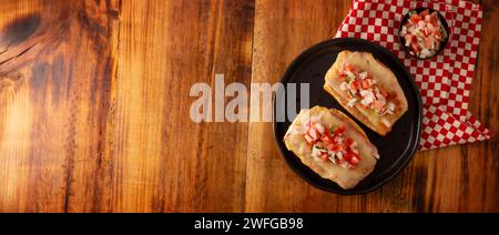 Molletes. Recette mexicaine à base de pain bolillo fendu dans le sens de la longueur, tartiné de haricots frits et de fromage gratiné, ajoutant de la sauce Pico de gallo et un peu de pro Banque D'Images