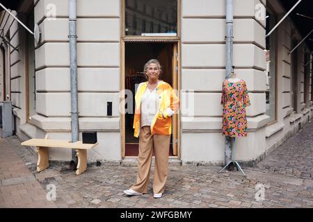 Portrait d'une propriétaire handicapée debout devant le magasin Banque D'Images