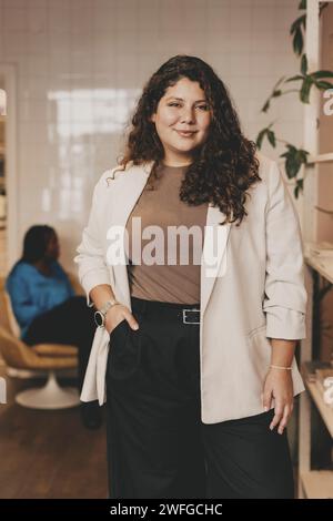 Portrait de femme d'affaires confiante debout avec la main dans la poche au bureau Banque D'Images