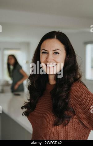 Portrait de femme mûre souriante debout à la maison Banque D'Images