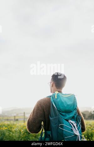 Vue arrière de l'homme avec sac à dos randonnée sous le ciel Banque D'Images