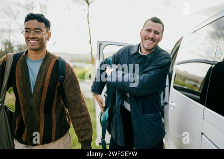 Amis masculins souriants avec des sacs à dos marchant en van Banque D'Images