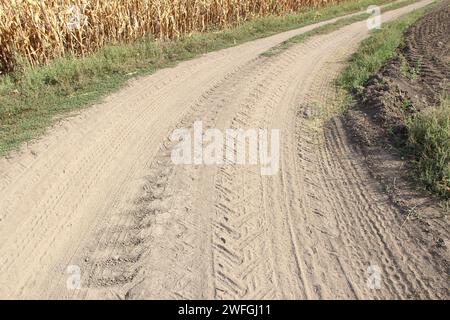 Pistes de machines agricoles sur la route rurale Banque D'Images