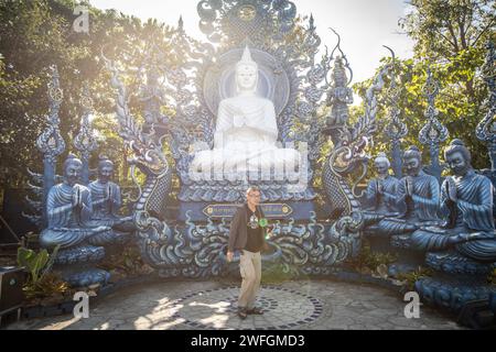 Chiang Rai, Thaïlande. 19 janvier 2024. Une promenade touristique locale près d'une statue de Bouddha. Wat Rong Suea Ten (Temple du Tigre dansant), plus communément connu sous le nom de ''Temple Bleu'' est une fusion des valeurs bouddhistes traditionnelles et de l'architecture thaïlandaise classique avec des choix de design contemporain, il a été conçu par Putha Kabkaew, un étudiant de l'artiste qui a construit le très connu ''Temple blanc' (image de crédit : © Guillaume Payen/SOPA Images via ZUMA Press Wire) USAGE ÉDITORIAL SEULEMENT! Non destiné à UN USAGE commercial ! Banque D'Images