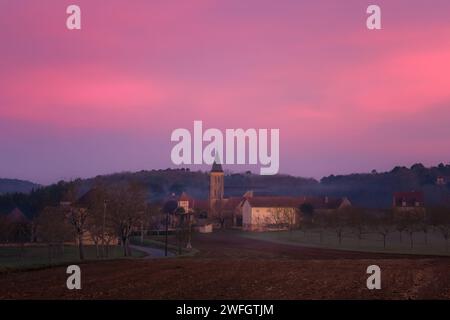 Rose et violet aube se levant au lever du soleil sur le village rural de Nabirat dans la région de Dordogne en France Banque D'Images