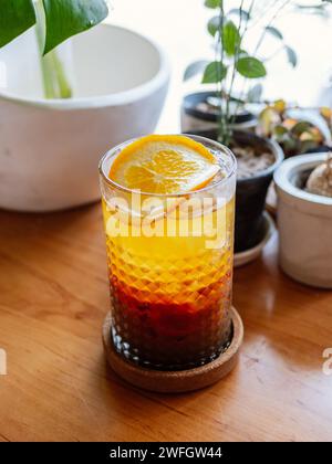 Un verre de cocktail bourré avec de la glace. Double espresso avec du jus d'orange et sirop de caramel avec du jus d'orange avec des tranches d'orange sur le verre. Frais et Banque D'Images