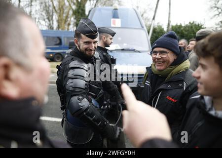 Les agriculteurs du syndicat CR47 (coordination rurale 47) font face à des gendarmes les empêchant d'aller plus loin à Sigloy près d'Orléans, France le 31 janvier 2024, en route pour bloquer le marché de Rungis, en périphérie de Paris. Le président français Macron a exhorté l’Union européenne à faire des concessions aux agriculteurs furieux qui ont juré d’encercler la capitale et de « affamer les Parisiens » en coupant les approvisionnements alimentaires. Huit routes clés à l'entrée et à la sortie de Paris sont actuellement bloquées par plus d'un millier de tracteurs, tandis que des balles de foin le long des routes ont été incendiées et des épouvantails suspendus aux ponts. Des dizaines d'autres Banque D'Images