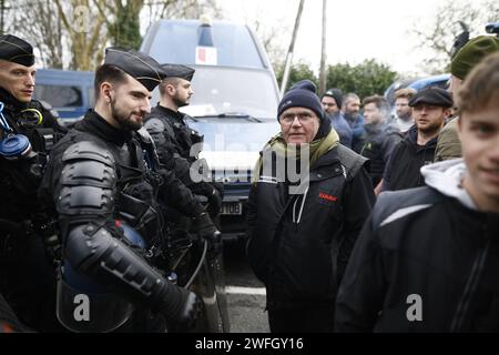 Les agriculteurs du syndicat CR47 (coordination rurale 47) font face à des gendarmes les empêchant d'aller plus loin à Sigloy près d'Orléans, France le 31 janvier 2024, en route pour bloquer le marché de Rungis, en périphérie de Paris. Le président français Macron a exhorté l’Union européenne à faire des concessions aux agriculteurs furieux qui ont juré d’encercler la capitale et de « affamer les Parisiens » en coupant les approvisionnements alimentaires. Huit routes clés à l'entrée et à la sortie de Paris sont actuellement bloquées par plus d'un millier de tracteurs, tandis que des balles de foin le long des routes ont été incendiées et des épouvantails suspendus aux ponts. Des dizaines d'autres Banque D'Images