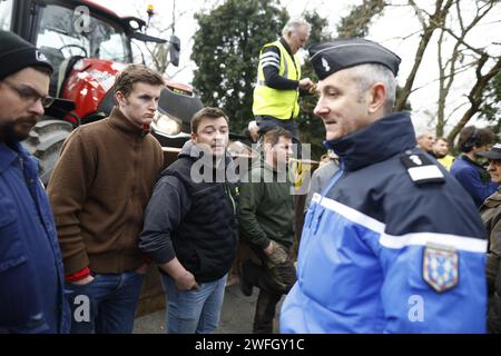 Les agriculteurs du syndicat CR47 (coordination rurale 47) font face à des gendarmes les empêchant d'aller plus loin à Sigloy près d'Orléans, France le 31 janvier 2024, en route pour bloquer le marché de Rungis, en périphérie de Paris. Le président français Macron a exhorté l’Union européenne à faire des concessions aux agriculteurs furieux qui ont juré d’encercler la capitale et de « affamer les Parisiens » en coupant les approvisionnements alimentaires. Huit routes clés à l'entrée et à la sortie de Paris sont actuellement bloquées par plus d'un millier de tracteurs, tandis que des balles de foin le long des routes ont été incendiées et des épouvantails suspendus aux ponts. Des dizaines d'autres Banque D'Images