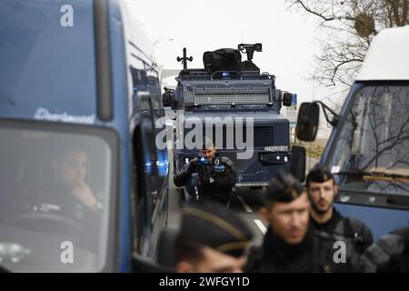 Les agriculteurs du syndicat CR47 (coordination rurale 47) font face à des gendarmes les empêchant d'aller plus loin à Sigloy près d'Orléans, France le 31 janvier 2024, en route pour bloquer le marché de Rungis, en périphérie de Paris. Le président français Macron a exhorté l’Union européenne à faire des concessions aux agriculteurs furieux qui ont juré d’encercler la capitale et de « affamer les Parisiens » en coupant les approvisionnements alimentaires. Huit routes clés à l'entrée et à la sortie de Paris sont actuellement bloquées par plus d'un millier de tracteurs, tandis que des balles de foin le long des routes ont été incendiées et des épouvantails suspendus aux ponts. Des dizaines d'autres Banque D'Images