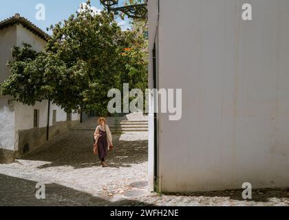 Femme marchant sous le grand arbre dans l'Albacin, Grenade Espagne Banque D'Images