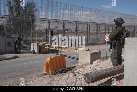 Un soldat israélien monte la garde au terminal de Nitzana où des camions entrent en Israël depuis l’Égypte pour inspection avant d’être envoyés à Rafah pour entrer dans Gaza le 30 janvier 2024 à Nitzana, en Israël. Banque D'Images