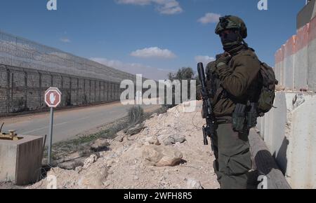 Un soldat israélien monte la garde au terminal de Nitzana où des camions entrent en Israël depuis l’Égypte pour inspection avant d’être envoyés à Rafah pour entrer dans Gaza le 30 janvier 2024 à Nitzana, en Israël. Banque D'Images