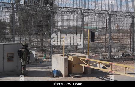 Un soldat israélien monte la garde au terminal de Nitzana où des camions entrent en Israël depuis l’Égypte pour inspection avant d’être envoyés à Rafah pour entrer dans Gaza le 30 janvier 2024 à Nitzana, en Israël. Banque D'Images