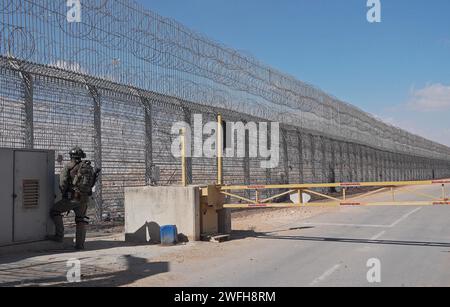 Un soldat israélien monte la garde au terminal de Nitzana où des camions entrent en Israël depuis l’Égypte pour inspection avant d’être envoyés à Rafah pour entrer dans Gaza le 30 janvier 2024 à Nitzana, en Israël. Banque D'Images