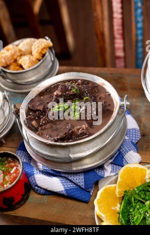 Plat typiquement brésilien feijoada à base de haricots noirs et de porc avec crakloing, riz et orange Banque D'Images