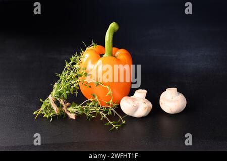 Champignons champignons et paprika avec branche de thym sur fond bleu foncé. Banque D'Images