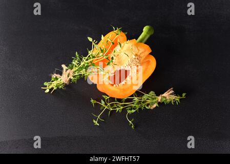 Champignons champignons et paprika avec branche de thym sur fond sombre. Banque D'Images