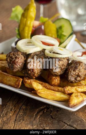 Cevapcici avec frites et anneaux d'oignon Banque D'Images