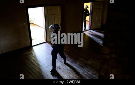 Hohenbostel, Allemagne. 03 janvier 2024. Les policiers de l ' unité de disposition des Lüneburg s ' entraînent à pénétrer dans un bâtiment. Crédit : Philipp Schulze/dpa/Alamy Live News Banque D'Images