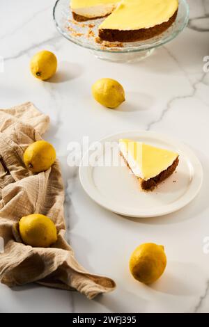 Cheesecake au mascarpone avec caillé de citron et base de sablé. Fond de marbre blanc. Photo de nourriture haute touche Banque D'Images