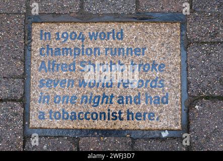 Plaques de tourisme dans le trottoir à Middle Street Horsham , West Sussex , Angleterre Royaume-Uni . Celui-ci célèbre le coureur Albert Shrubb Banque D'Images