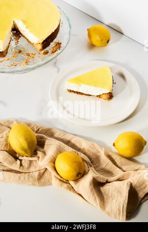 Cheesecake au mascarpone avec caillé de citron et base de sablé. Fond de marbre blanc. Photo de nourriture haute touche Banque D'Images