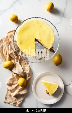 Cheesecake au mascarpone avec caillé de citron et base de sablé. Fond de marbre blanc. Photo de nourriture haute touche Banque D'Images