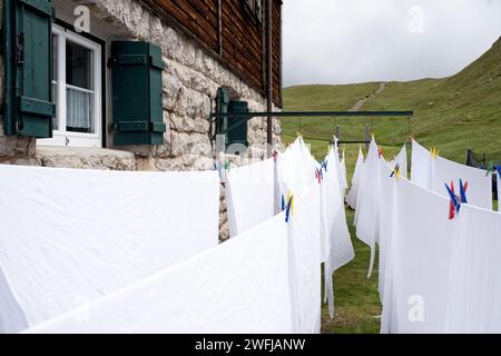 Draps blancs traînent pour sécher à l'extérieur d'une retraite de montagne des montagnes Dolomites Banque D'Images