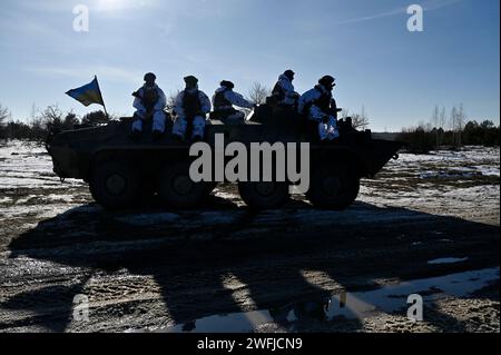 Zhytomyr, Ukraine. 30 janvier 2024. Des militaires ukrainiens vus au sommet d'un véhicule blindé de transport de troupes (APC) lors d'exercices militaires dans la région de Zhytomyr. (Photo de Sergei Chuzavkov/SOPA Images/Sipa USA) crédit : SIPA USA/Alamy Live News Banque D'Images