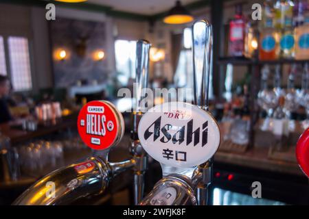 Gros plan du panneau Asahi Super Dry Beer et du kanji sur une pompe à main dans un pub à Londres, Angleterre, Royaume-Uni Banque D'Images