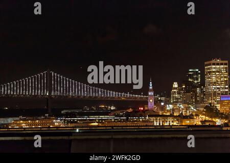 Front de mer de San Fransisco et Oakland Bridge la nuit Banque D'Images