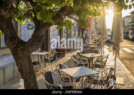 Café en plein air dans une belle rue avec des maisons traditionnelles azulejos portugaises à Tavira Banque D'Images