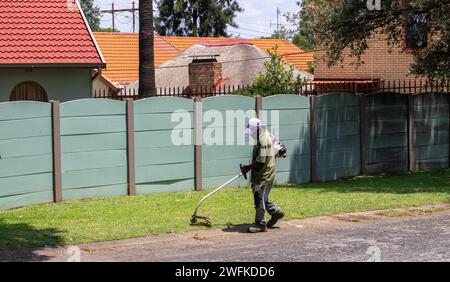 Johannesburg, Afrique du Sud - un travailleur migrant non identifié effectue des travaux manuels de jardinage pour gagner sa vie Banque D'Images