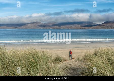 Vue à travers les dunes de Traigh Rosamol sur la plage de Luskentyre avec un randonneur et un chien Border terrier Banque D'Images
