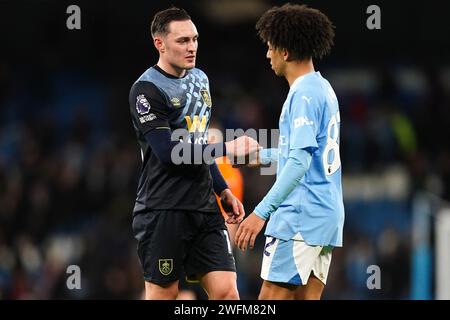 Connor Roberts de Burnley (à gauche) et Rico Lewis de Manchester City serrent la main après le coup de sifflet final du match de Premier League à l'Etihad Stadium, Manchester. Date de la photo : mercredi 31 janvier 2024. Banque D'Images