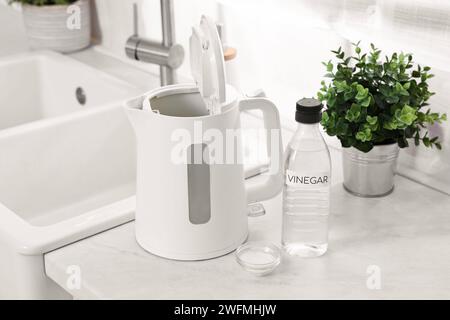 Nettoyage de la bouilloire électrique. Bouteille de vinaigre et bicarbonate de soude sur le comptoir dans la cuisine Banque D'Images