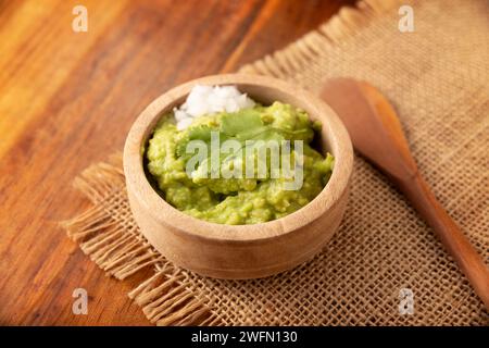 Guacamole. La sauce DIP à l'avocat, l'une de ses nombreuses façons de la consommer, est étalée sur des chips tortilla également appelées Nachos. Recette de sauce maison facile mexicaine Banque D'Images