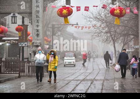 QINGZHOU, CHINE - 31 JANVIER 2024 - les touristes jouent dans l'ancienne ville de Qingzhou avec des vêtements épais rembourrés de coton dans le Shandong de Chine orientale Banque D'Images