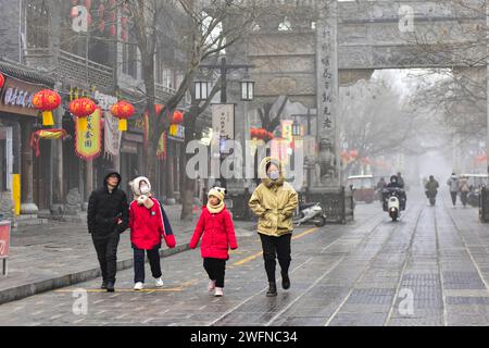 QINGZHOU, CHINE - 31 JANVIER 2024 - les touristes jouent dans l'ancienne ville de Qingzhou avec des vêtements épais rembourrés de coton dans le Shandong de Chine orientale Banque D'Images