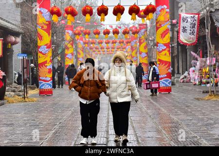 QINGZHOU, CHINE - 31 JANVIER 2024 - les touristes jouent dans l'ancienne ville de Qingzhou avec des vêtements épais rembourrés de coton dans le Shandong de Chine orientale Banque D'Images